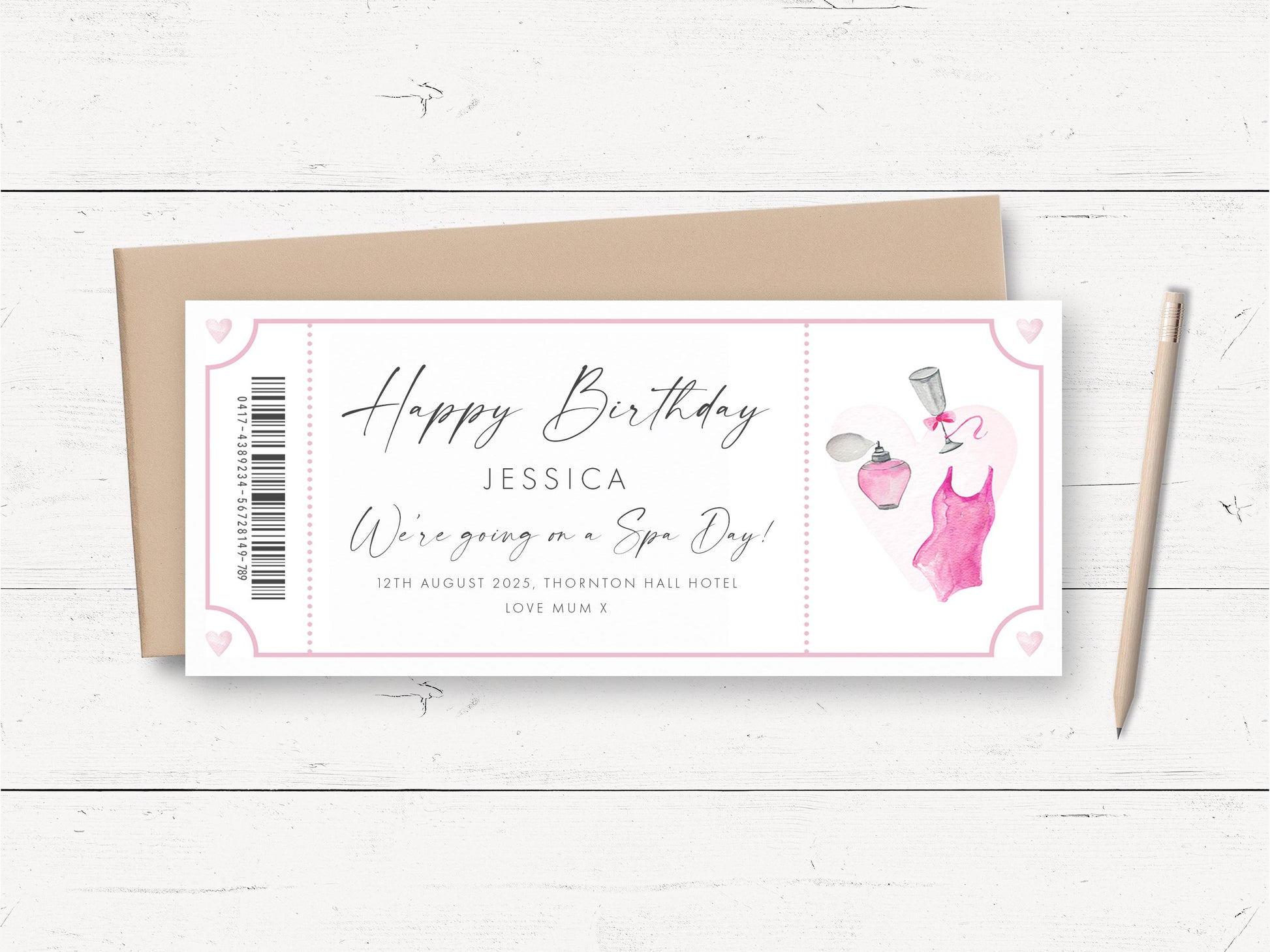 A birthday card with a pink and white color scheme, featuring a design with a perfume bottle and a pink dress. The card is placed on a white wooden surface, accompanied by a pencil and a brown envelope.