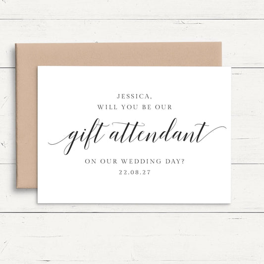 a wedding invitation card with a brown envelope placed on a white wooden surface.