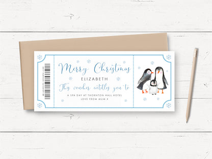 A white card with a blue border and a picture of two penguins, along with text that reads "Merry Christmas Elizabeth This voucherentley you to a spa day at Thornington hall hotel. Love from Mum X".