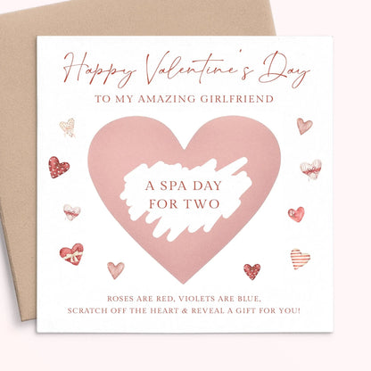 The image is a Valentine's Day card with a pink heart-shaped design and various heart-shaped and heart-themed illustrations surrounding it. The card has a message that reads "Happy Valentine's Day to my amazing girlfriend" and "A spa day for two" along with a list of items such as "Roses are red, violets are blue, scratch off the heart & reveal a gift for you!"