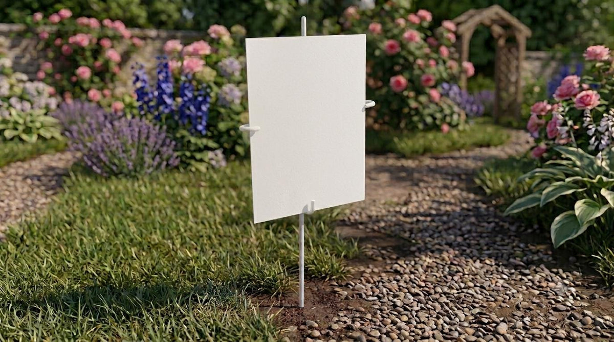 A white sign stands in a lush garden filled with colorful flowers and greenery.