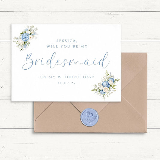 A white card with a floral design and a blue wax seal, placed on a wooden surface.