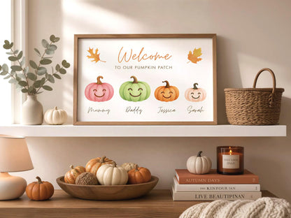 a framed sign that reads "Welcome to our pumpkin patch" with illustrations of four different types of pumpkins. The pumpkins are labeled "Mummy", "Daddy", " Jessica", and "Sarah". The pumpkins are displayed on a shelf, along with a vase of greenery, a candle, and a stack of books.