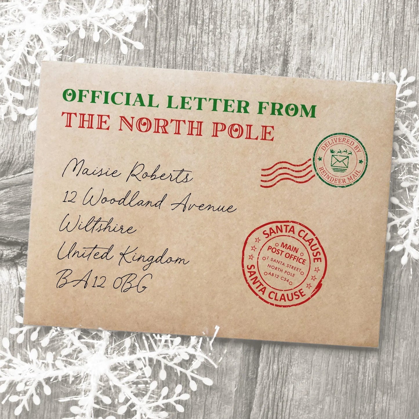 The image is an official letter from the North Pole addressed to Maisie Roberts, located at 12 Woodland Avenue, Wiltshire, United Kingdom. The letter is addressed to Santa Claus and is marked as a Santa Claus envelope.