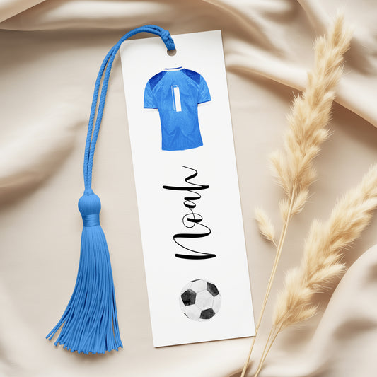 A personalized bookmark with a blue tassel and a soccer ball design, along with the name "Noah" written on it.
