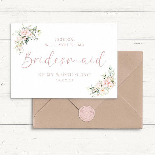 A wedding invitation card with a floral design and a pink wax seal.