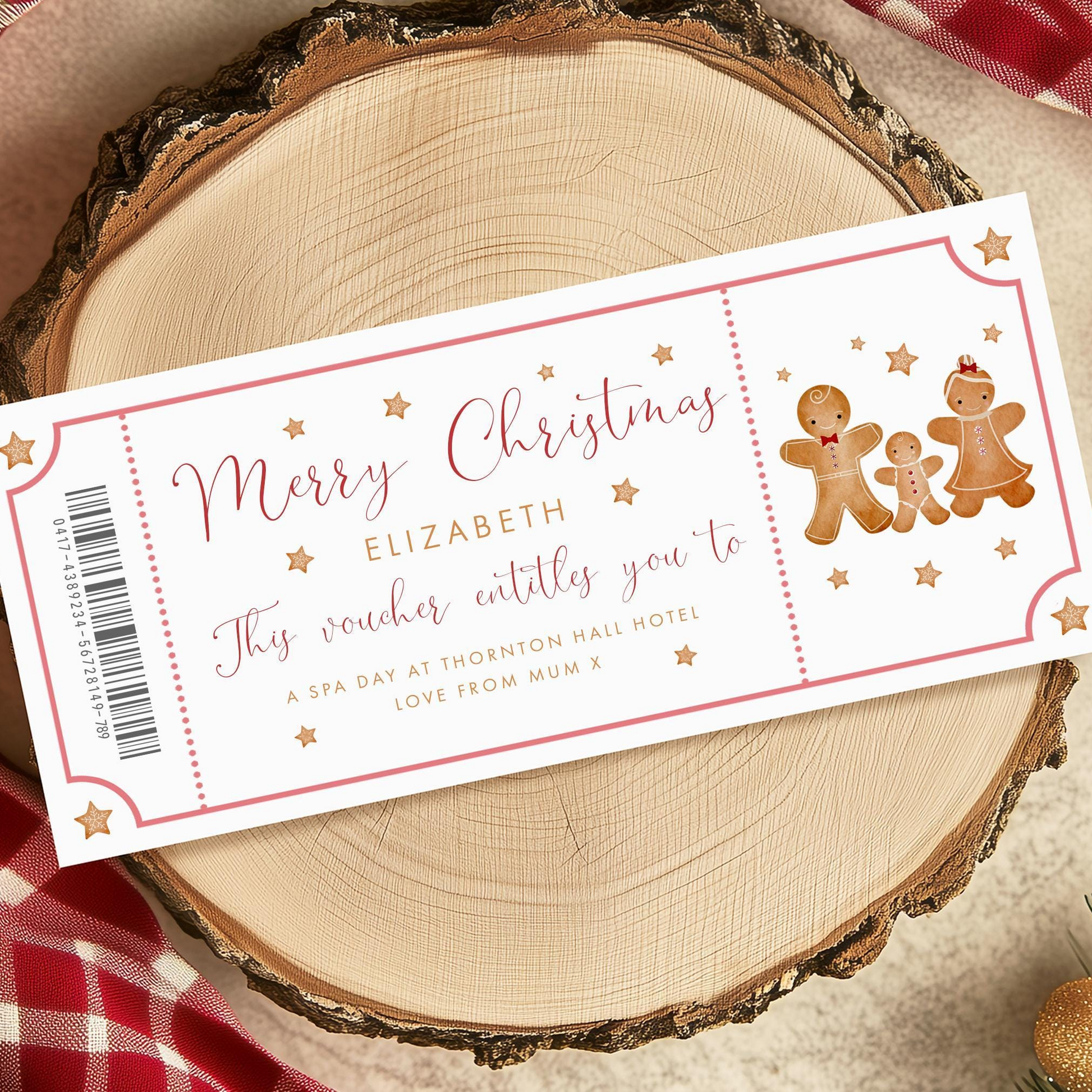 A Christmas-themed gift voucher for Elizabeth, featuring gingerbread men and stars, is displayed on a wooden surface.