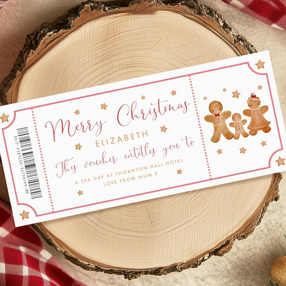 A Christmas-themed gift voucher for Elizabeth, featuring gingerbread men and stars, is displayed on a wooden surface.
