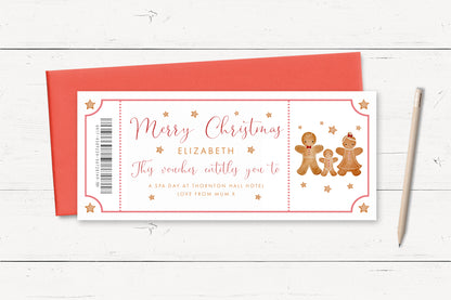 A Christmas-themed gift voucher for Elizabeth, featuring a gingerbread man and stars, placed on a wooden surface next to a pencil.